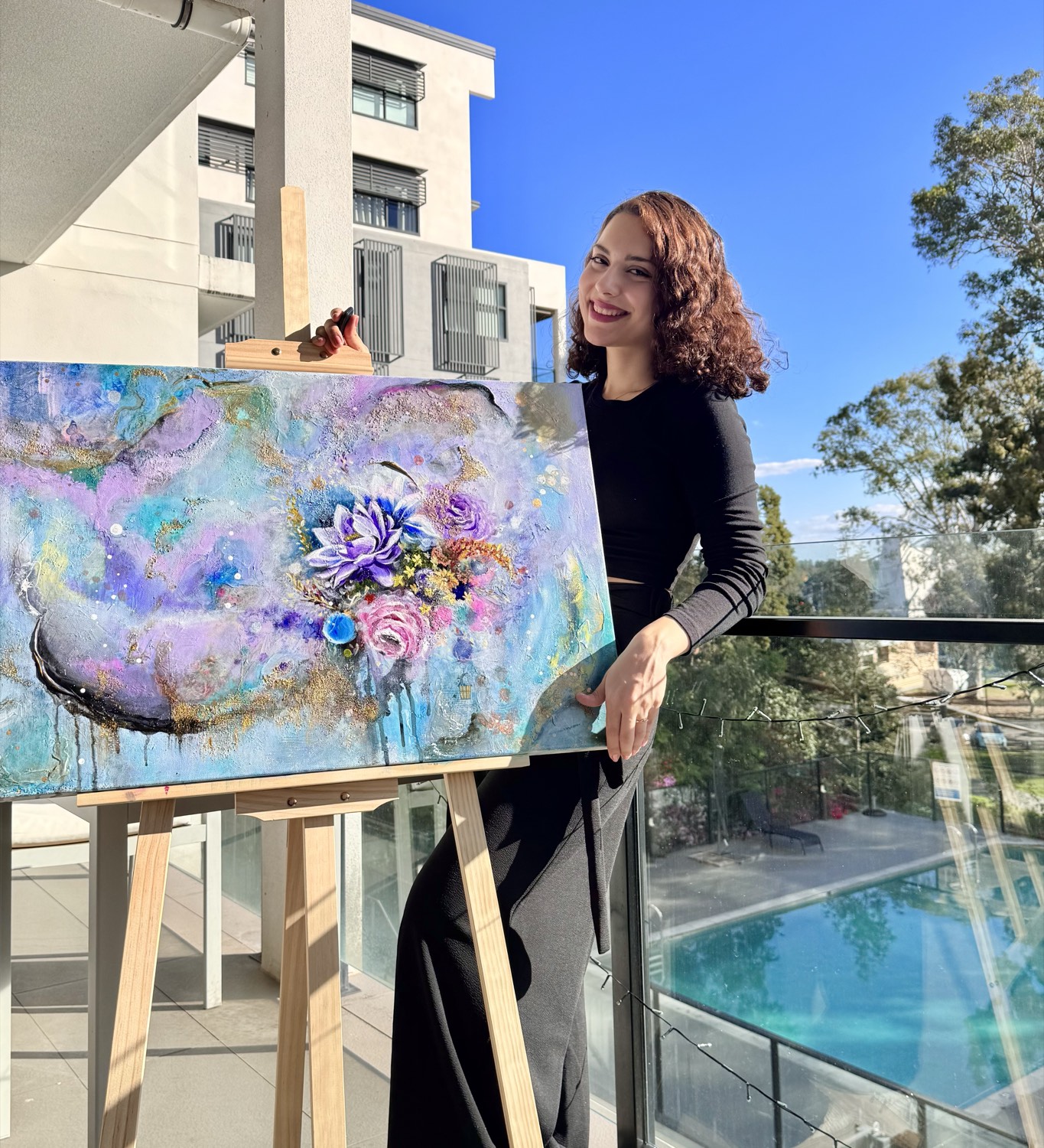 Dorsa Azarfar beside one of her paintings on an easel